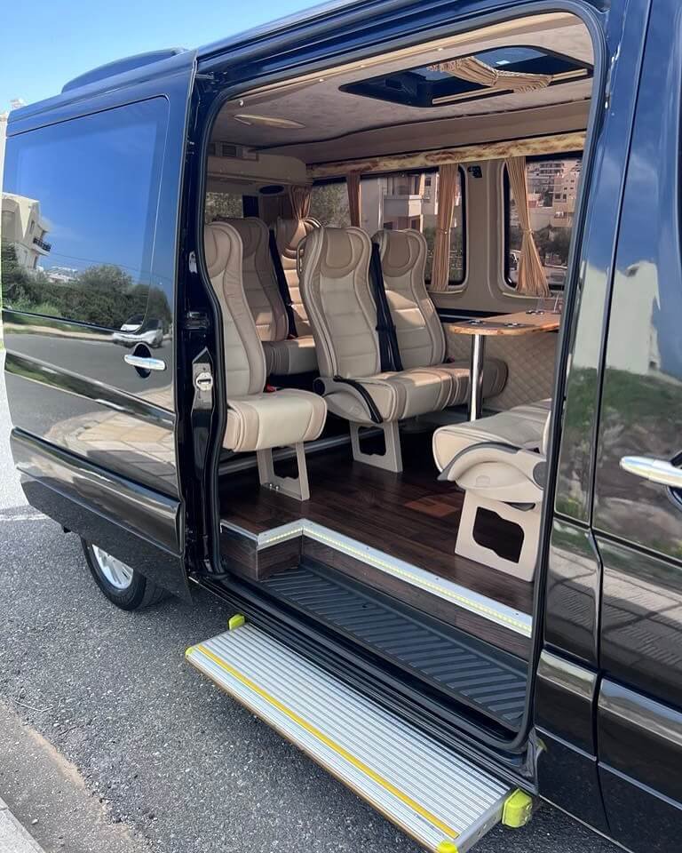 Interior of a luxury Mercedes transfer van with leather seats and easy access step for private tours in Crete